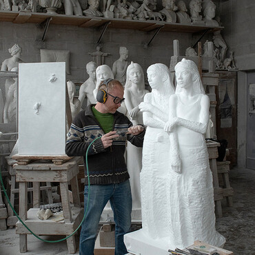 Mann in Werkstatt arbeitet an Marmor-Skulptur