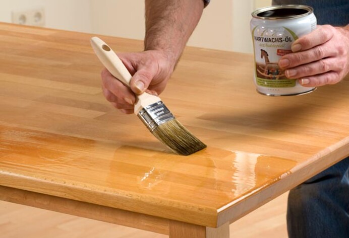 Tisch wird mit Pinsel gewachst