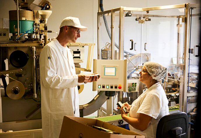 Mitarbeiter von Samen Maier bei der Qualit&auml;tskontrollIm Gespr&auml;ch: Johannes Huber und Mitarbeiterin Rebecca Appelius vor einer Abf&uuml;llmaschine.