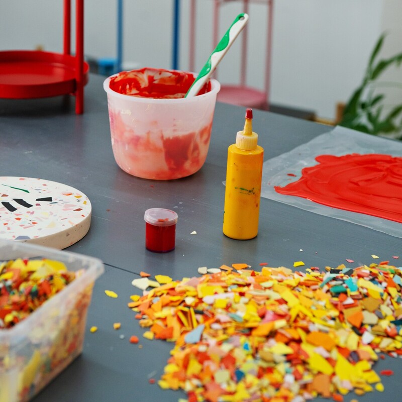 Auf einem Tisch liegen bunte Chips für Terrazzo-DIY