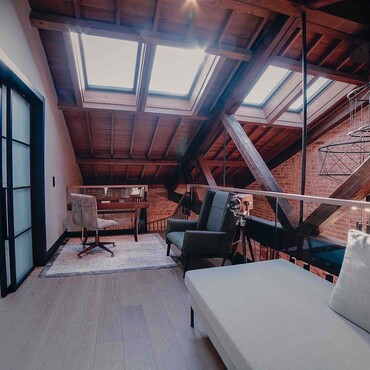 Ausgebauter Dachboden mit Dachschräge, Couch und Schlafzimmer mit Schiebetüren