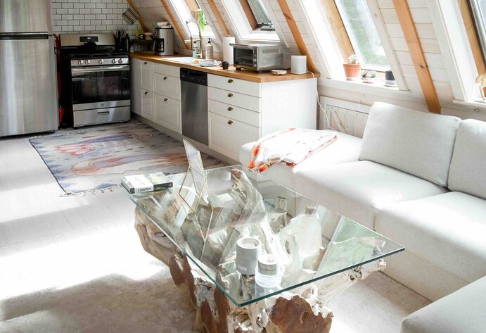 Ausgebauter Dachboden mit Einbauküche und Glastisch im Wohnbereich