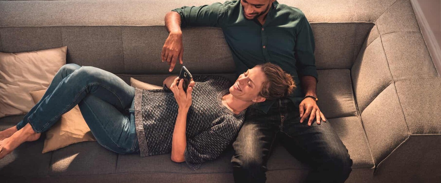 Pärchen auf Couch macht sich mit dem Bosch Smart Home System vertraut