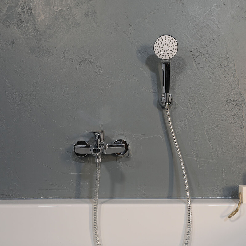 Grau verputze Wand hinter der Badewanne